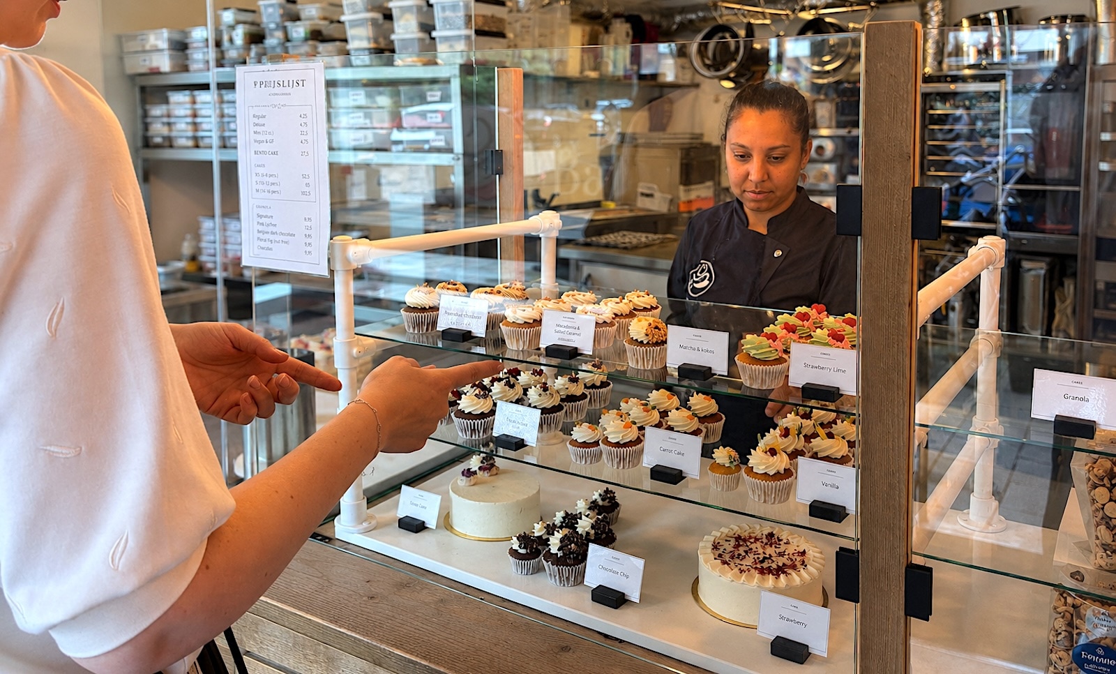 Faryel Bhailal achter de vitrine van Amsterdam Cupcake Company. Amsterdam Cupcake Company | Faryel Bhailal achter de vitrine van haar bakkerij tijdens 15-jarig jubileum