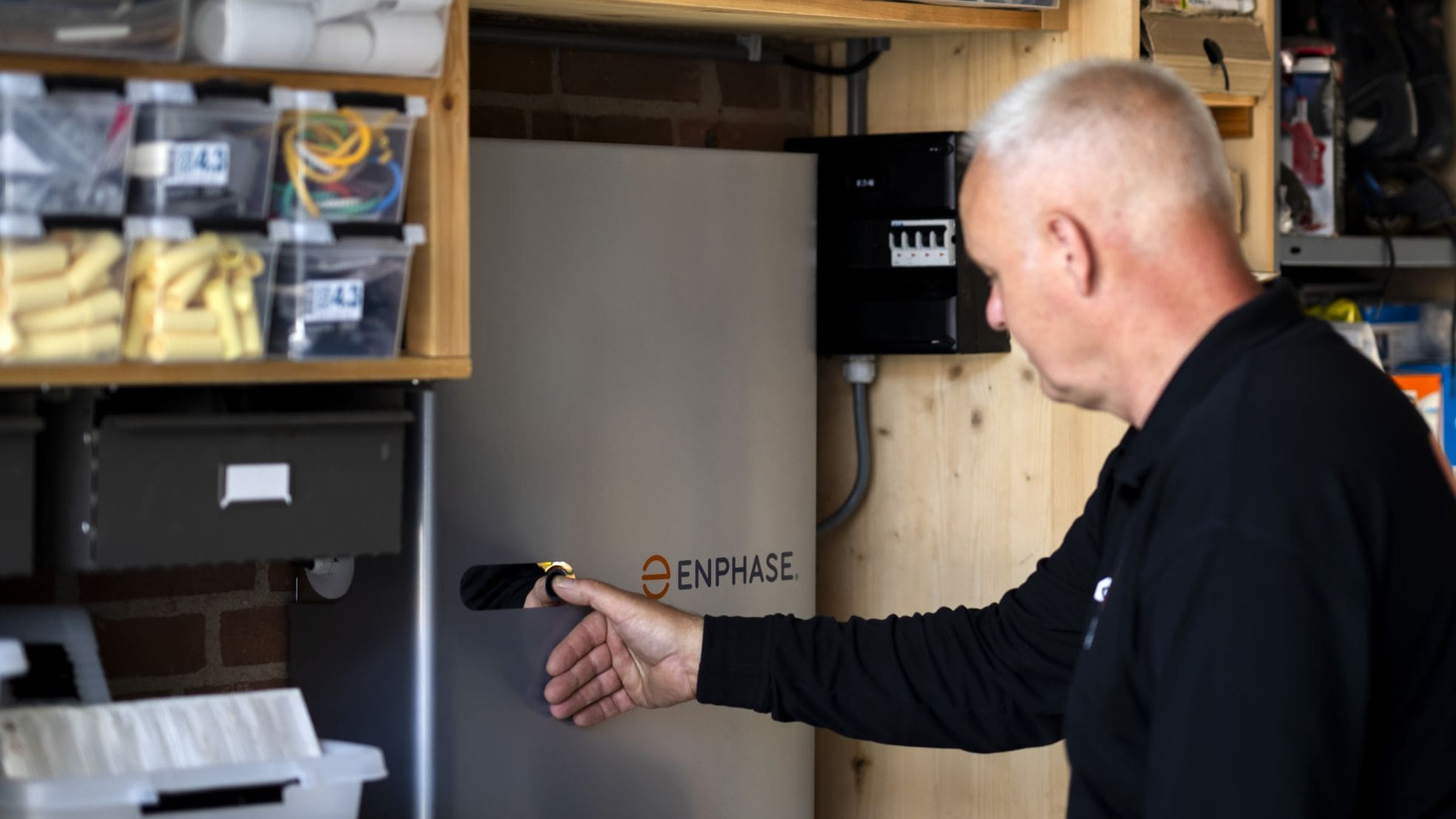 Een monteur installeert een thuisbatterij in een woning.