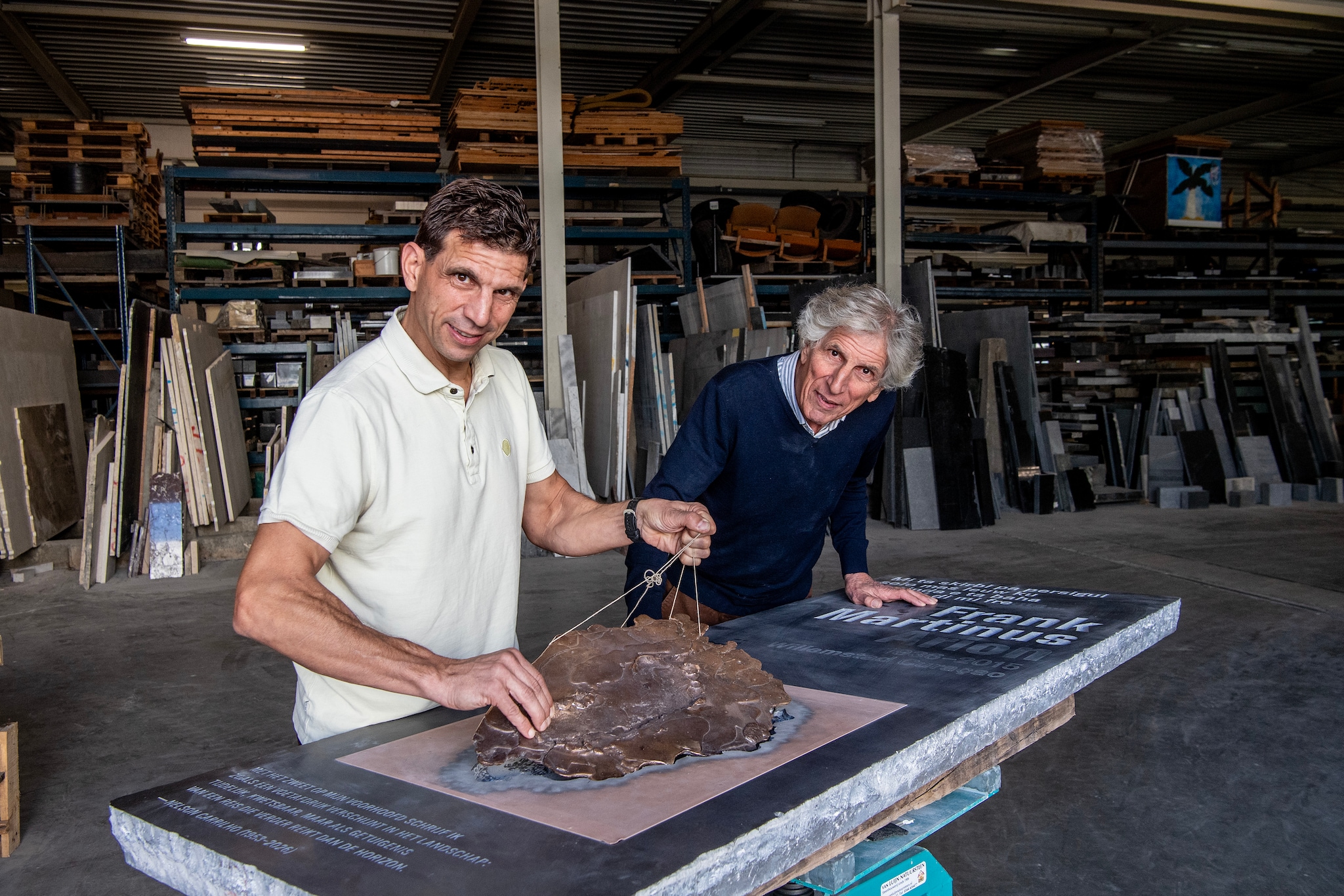 Gerard (rechts) en Michiel van Luijn bij de schrijverssteen voor Frank Martinus Arion. In de steen zit een bronzen voetafdruk verwerkt.